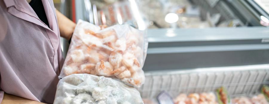 Shopper holding frozen shrimp